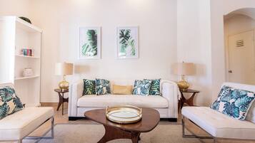 A living room with a sofa, two side tables, a coffee table, and a bookshelf.