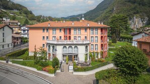 Ein mehrstöckiges Hotel mit Innenhof, umgeben von üppiger Vegetation und Hügeln.