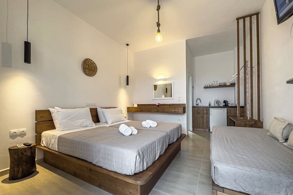 Una habitación de hotel moderna con una cama grande, un escritorio pequeño y una kitchenette.