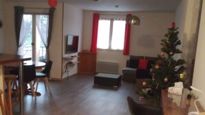 Un soggiorno con zona pranzo, un tavolino e un albero di Natale.