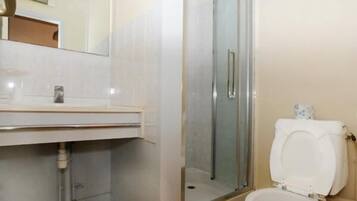 Un baño con ducha, inodoro y lavamanos.