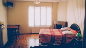 A bedroom with a bed, a desk, and a fireplace. - Hotel Restaurant Maurice (Chateauroux)