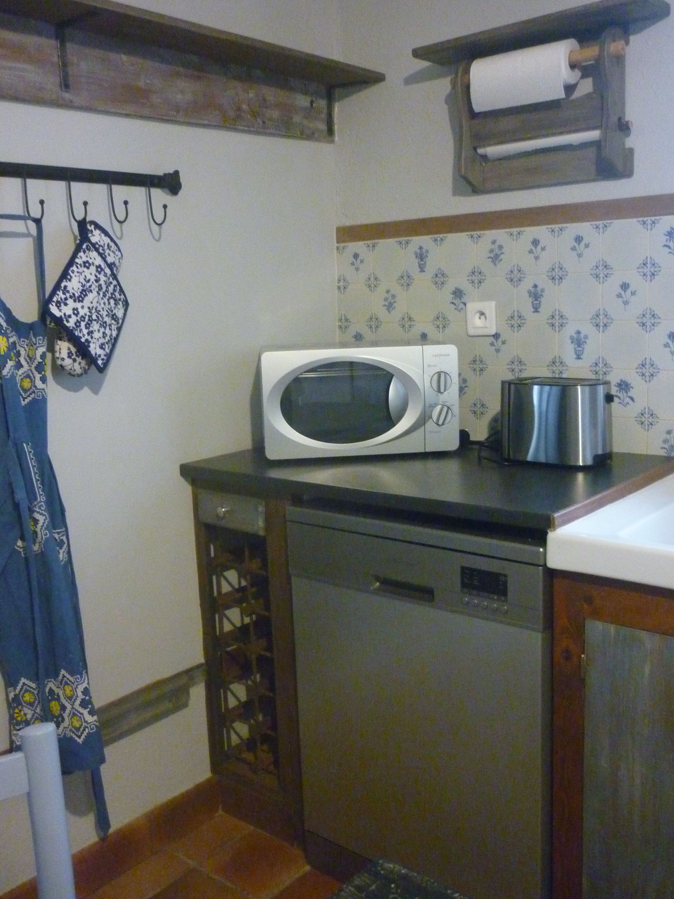 A compact kitchen with a microwave, toaster, and dishwasher.