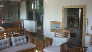 Un intérieur rustique avec une table à manger en bois, des chaises, un canapé et une cheminée.