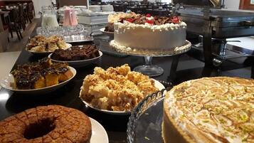 A buffet table with various desserts including cakes, pies, and pastries.