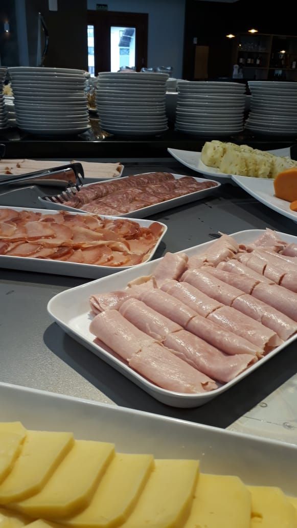 Ett buffébord med olika sorters mat, inklusive skivad kött och ost.
