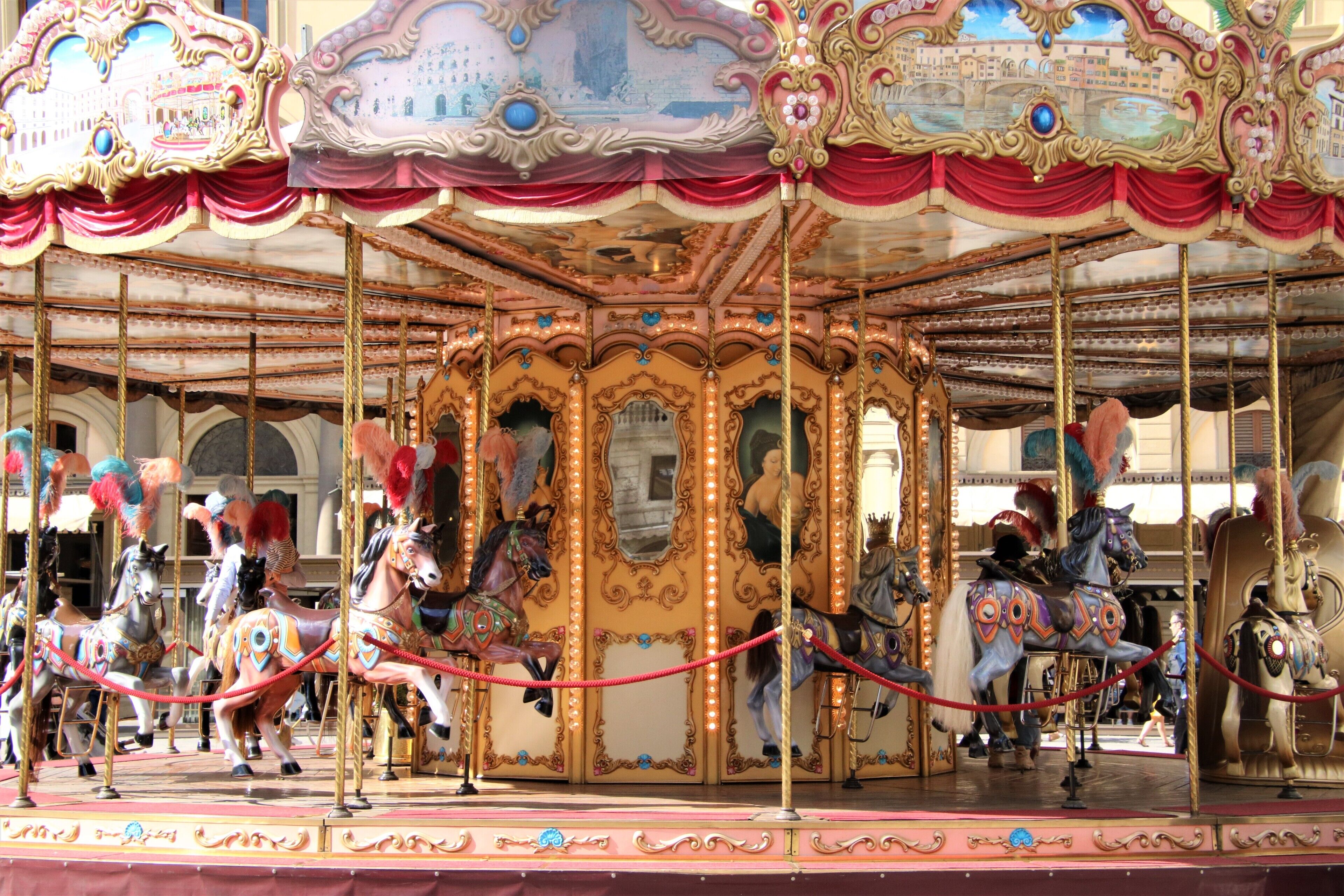 A carousel with ornate golden decorations and horses.