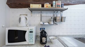 A kitchen with a microwave, coffee maker, and a shelf with kitchen items. - Elevator, Ac, Wifi - Heart of historic city center (Florence)