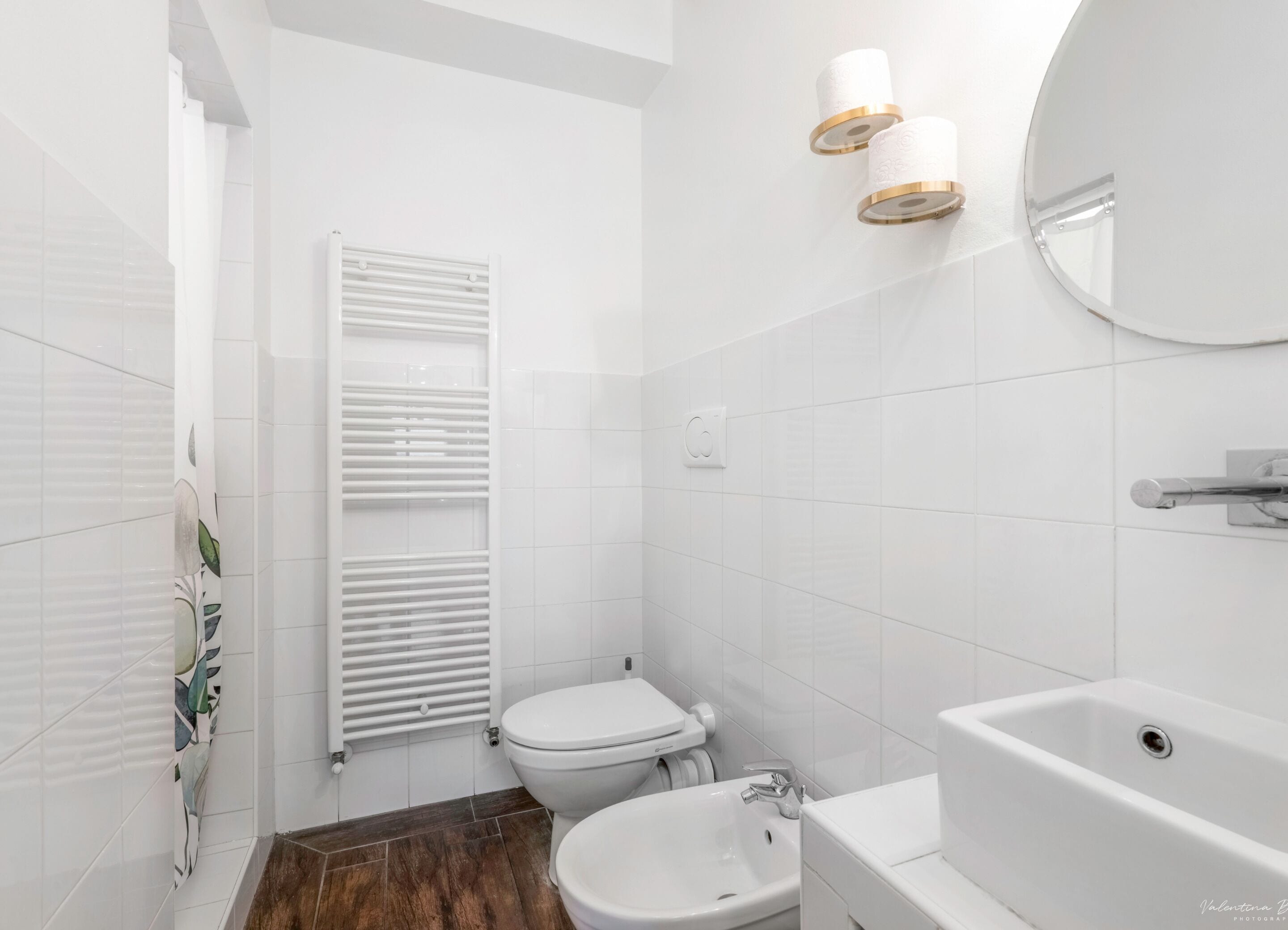 A modern bathroom with a toilet, bidet, sink, and a bathtub.