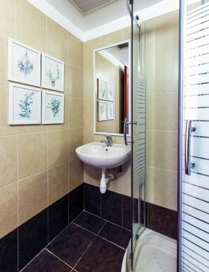 A bathroom with a sink, mirror, and framed botanical prints on the wall.