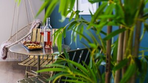 A table with a bottle of wine, glasses, and a plate of cheese and grapes. - New - Trendy One Bedroom Apt, Most Popular Area (Jerusalem)