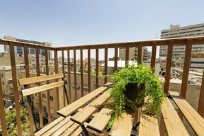 A balcony with wooden railings and a potted plant.