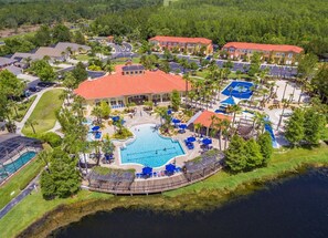A resort with a central swimming pool, multiple tennis courts, and a variety of outdoor seating areas. - 7 Bedroom Villa, Private Pool, Resort Amenities (Kissimmee)