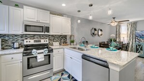 A modern kitchen with white cabinetry, a built-in microwave, an oven, and a dishwasher. - Family Vacation Home, Water Park+Endless Amenities (Kissimmee)