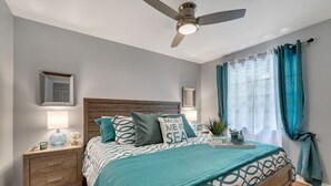 A bedroom with a bed, nightstands, a ceiling fan, and a window with curtains. - Family Vacation Home, Water Park+Endless Amenities (Kissimmee)