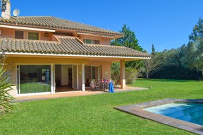 A two-story house with a patio and a swimming pool.