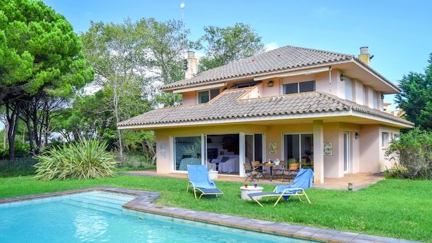 A two-story house with a swimming pool, outdoor seating, and a garden. - Villa 100 meters from the sea, in the Platja de Pals Golf Club. A/C (Pals)