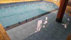 Een zwembad met betegelde rand en helder water.