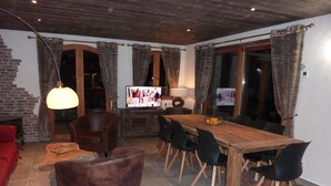 A cozy living room with a wooden dining table, leather chairs, and a TV. - New apartment 8 people in chalet in Champagny / La Plagne (Champagny-en-Vanoise)