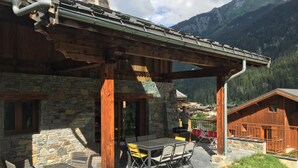A wooden chalet with stone walls, outdoor seating, and a mountain view. - New apartment 8 people in chalet in Champagny / La Plagne (Champagny-en-Vanoise)