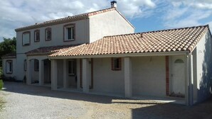 A two-story house with a tiled roof and a covered porch area. - La Maison Familiale (Lagarrigue)