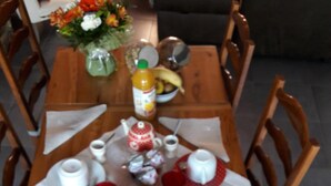 A dining table set with various breakfast items including croissants, a bowl of fruit, and cups. - La Maison Familiale (Lagarrigue)