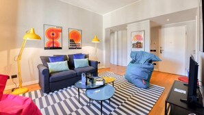 Una sala de estar moderna con un sofá, una mesa de centro y obras de arte en las paredes.