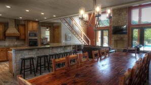 Une cuisine spacieuse dotée d’un grand îlot central, de tabourets de bar et d’un mur décoratif en pierre.