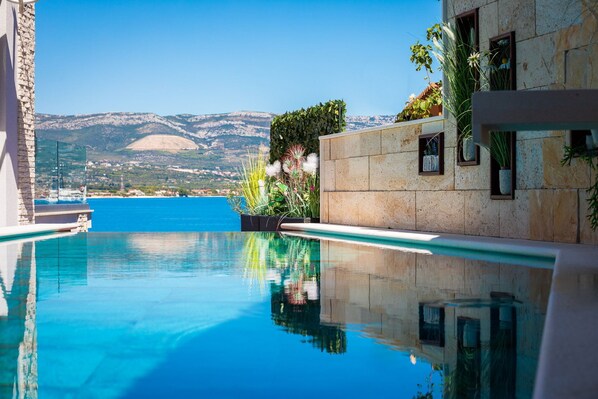A clear blue pool with a view of the sea and mountains in the background. - Villa Arbanessa with Heated Pool (Arbanija)