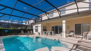 A swimming pool with lounge chairs and a covered patio area.