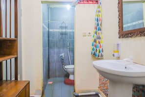 A bathroom with a toilet, sink, shower, and a wooden shelf. - Hotel O Superbedroom (Depok)