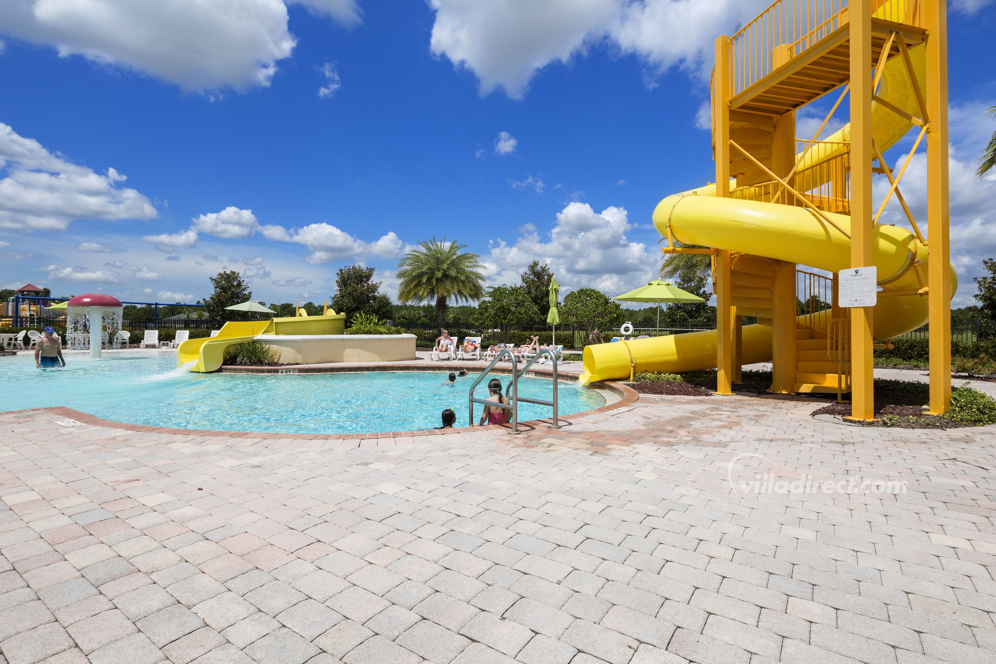 Ein Schwimmbecken mit gelber Wasserrutsche und Rettungsschwimmerstation.