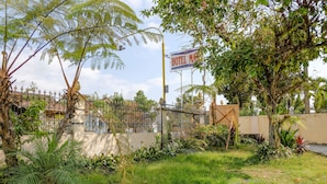 A fenced garden area with a sign for a hotel. - Hotel O Maya (Beru)