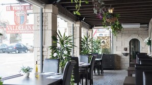 Een terras met stenen muren, tafels en stoelen.