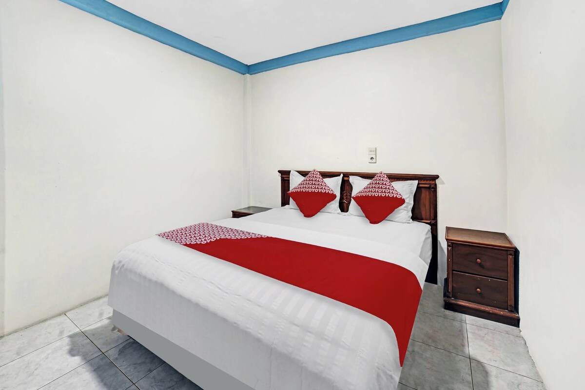 Un dormitorio con una cama, una mesita de noche y un zócalo azul.