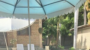 Desayuno junto a la piscina con una mesa, sillas y vistas al agua.