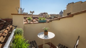 A small balcony with potted plants, a metal watering can, and a white table. - San Lorenzo Terrace Duomo View, near the SMN station, Tram, Market. AC provided (Firenze)