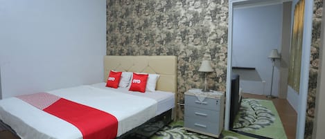 A bedroom with a bed, a dresser, a mirror, and a patterned rug.