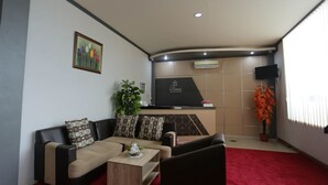 Una sala de estar con un sofá, una mesa de centro y un televisor montado en la pared.