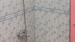 Ducha con cabezal de ducha de mano y grifo empotrado.