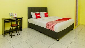 Una habitación de hotel con una cama, un escritorio y una silla.