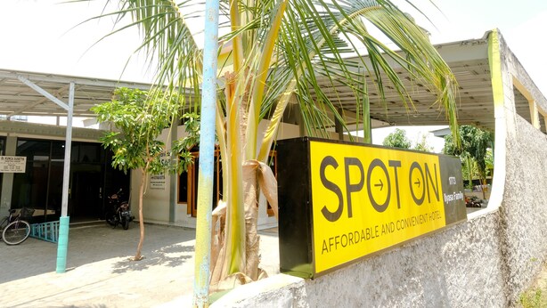 A hotel sign with the name "SPOT ON" and a description of being affordable and convenient.