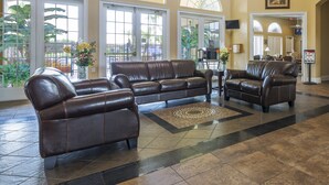 A spacious lobby with leather sofas, large arched windows, and a tiled floor. - Taragon by VillaDirect (Kissimmee)