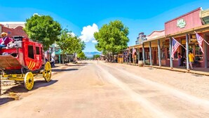 A historic street with a red carriage, storefronts, and American flags. - Historic San Jose House Room 2 Wyatt Earp (Tombstone)