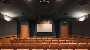 A theater with rows of seats, a large screen, and a projector. - Sable Palms Villa by VillaDirect (Kissimmee)