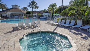 A swimming pool with lounge chairs and a hot tub area, surrounded by palm trees and a covered patio. - Sable Palms Villa by VillaDirect (Kissimmee)