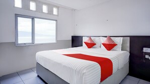 Une chambre à coucher moderne avec un grand lit, deux fenêtres et une vue sur le ciel.
