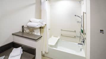 Ein modernes Badezimmer mit einer Badewanne, einem Waschtisch mit Handtuchhalter und einer Duschkabine.