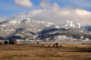 Et landligt landskab med et snedækket bjerg, en mindre bygning og en klar himmel.