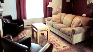 A living room with a sofa, two armchairs, a coffee table, and a patterned rug. - Paintbrush North- clean & quiet home with mountain views (West Yellowstone)
